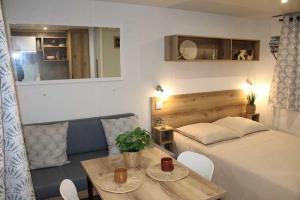 a bedroom with a bed and a table with chairs at Camping de Charlieu in Charlieu