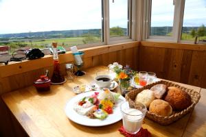 a table with a plate of bread and a basket of food at Heart'n Tree in Tsurui