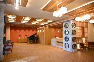 a lobby of a hotel with a piano and chairs at Landmark Hotel in Batumi