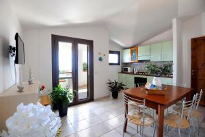 een keuken en eetkamer met een tafel en stoelen bij Suite Torrigiani in Cala Gonone