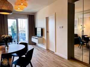 a living room with a table and chairs and a dining room at Apartament na wydmie - Perłowa Przystań in Sianozety