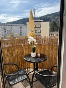 a patio table with two chairs and an umbrella at Bergblick Balkon Bruck an der Mur in Bruck an der Mur