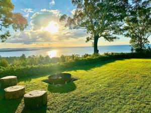 a park with a bench and a tree and the ocean at Aqua Straddies Best View Bay, Brissy & Beyond in Dunwich