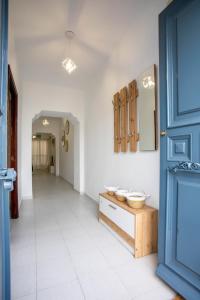 a hallway with a table and a blue door at Apartamento Casa Puerta del Sol I in Montijo +1 photo
