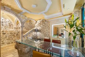 a dining room with a glass table and a staircase at Palmotta Palace in Dubrovnik
