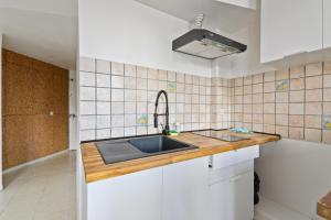 a kitchen with a sink and a tiled wall at Studio Apartment Quartier Austerlitz Free Netflix in Paris +3 photos