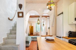 a living room with a table and a stairway at Romantic Mediterranean Riad in Tavernes de Valldigna