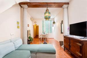 a living room with a couch and a flat screen tv at Romantic Mediterranean Riad in Tavernes de Valldigna