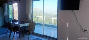 a room with a table and chairs and a balcony at Likya Vadi Evleri Nature and tranquility in Antalya