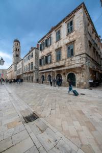a group of people walking around a large stone building at Palmotta Palace in Dubrovnik