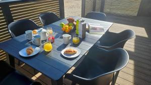 a blue table with breakfast foods and orange juice at Lerryn Lodge - 2 bedroom in Looe