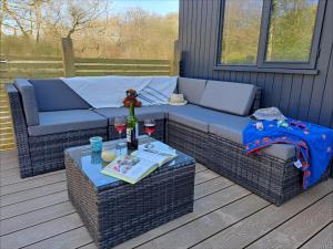 a couch and a table on a deck at Cardinham Lodge 3 bedroom - max 6 occ - VP4 in Looe