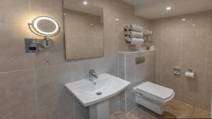 a bathroom with a sink and a toilet and a mirror at Best Western Corona Hotel in London +53 photos