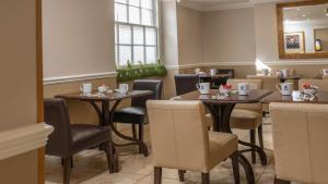 a restaurant with tables and chairs and a mirror at Best Western Corona Hotel in London