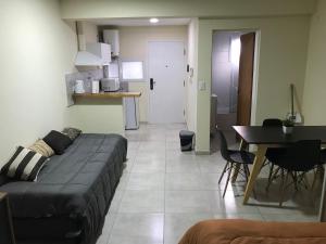 a living room with a couch and a table and a kitchen at Paola in Trelew
