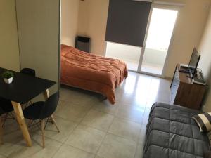 a bedroom with a bed and a table and a couch at Paola in Trelew