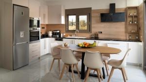 a kitchen with a table with a bowl of fruit on it at Villa Zachos in Pitsidia