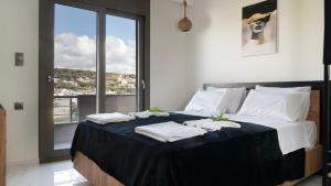 a bedroom with a large bed with towels on it at Villa Zachos in Pitsidia +36 photos