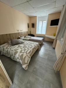 a bedroom with two beds and a television in it at Aquanerius Résidence in Néris-les-Bains