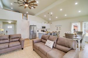 a living room with two brown couches and a kitchen at Waterfront Retreat on Greers Ferry Lake with Hot Tub in Heber Springs