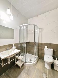 a bathroom with a shower and a toilet and a sink at Pensao Central in Matosinhos +32 photos
