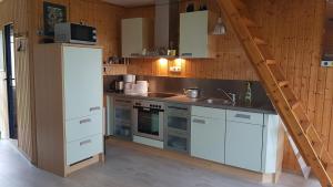 a kitchen with white cabinets and a white refrigerator at Tomi's Beach House in Gahlkow