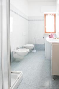 biała łazienka z wanną, umywalką i toaletą w obiekcie Le Palme 2 Pineto Vacanza w mieście Pineto