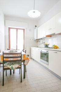 a kitchen with white cabinets and a table with a dining room at Le Palme 2 Pineto Vacanza in Pineto