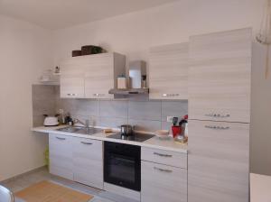 a kitchen with white cabinets and a sink at CasaNani in Germignaga