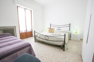 a white bedroom with a bed and a window at Le Palme 2 Pineto Vacanza in Pineto