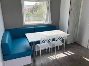 a blue couch and a table and chairs in a room at Posada IRIS in Puerto Lápice