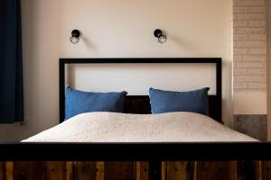 a bedroom with a large bed with blue pillows at Apartment By the River in Niš