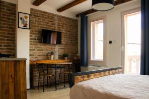 a bedroom with a brick wall and a table with chairs at Apartment By the River in Niš
