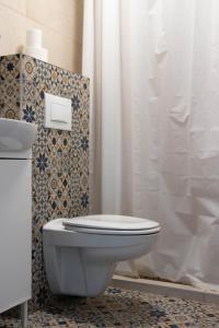a bathroom with a toilet and a shower curtain at Apartment By the River in Niš