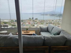 un salon avec un canapé et une grande fenêtre dans l'établissement Hermoso Departamento en Con Con Edificio Mares de Montemar, à Concón