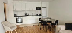 a kitchen and dining room with a table and chairs at Elme Apartment 1 in Växjö