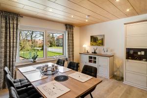 a dining room with a wooden table and chairs at Ferienhaus am Park in Heudeber