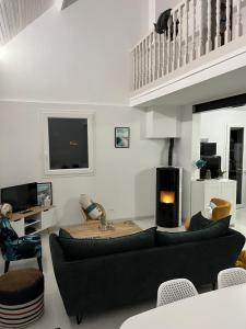 a living room with a black couch and a fireplace at Villa premium 150m de la plage in Barneville-Carteret