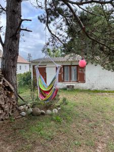 a hammock hanging from a tree in front of a house at Villa premium 150m de la plage in Barneville-Carteret