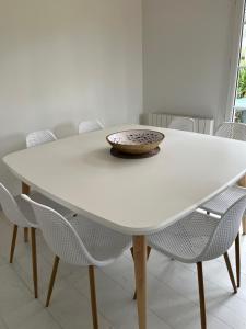 a white table with chairs and a bowl on top at Villa premium 150m de la plage in Barneville-Carteret +10 photos