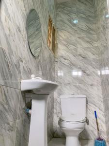 a bathroom with a toilet and a sink and a mirror at Betsy Apartments in Abuja +8 photos