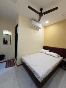 Un dormitorio con una cama con ventilador de techo. en Hotel Marine Line Near Churchgate, en Bombay