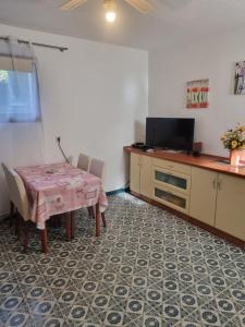 a kitchen with a table and chairs and a television at Apartment Lavanda in Pješčana Uvala