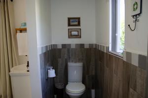 a bathroom with a toilet and a sink and a window at Hermanus Josh in Hluhluwe