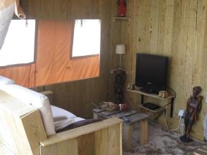 ein Schlafzimmer mit einem Bett und einem TV in einem Zimmer in der Unterkunft African Tent in Ponte da Barca