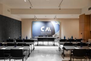 a large screen in a room with tables and chairs at Ilunion Hacienda de Mijas in Mijas +53 photos