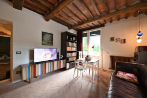 a living room with a couch and a tv at Villa Lucchesi in Bagni di Lucca
