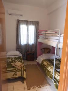 a room with two bunk beds and a window at Maria's Apartment in Lixouri +5 photos