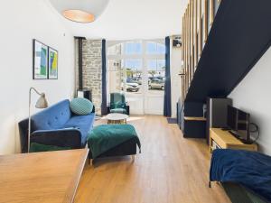 a living room with a blue couch and a tv at -COTTEN-grand duplex vue mer au coeur de Concarneau in Concarneau