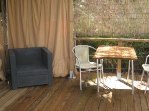 einen TV, einen Tisch und einen Stuhl auf einer Terrasse in der Unterkunft African Tent in Ponte da Barca